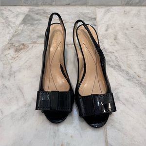Kate Spade black patent leather sandal heels with bow on the front.